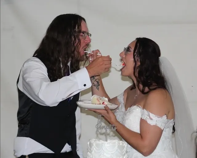 Newlyweds feeding each other wedding cake