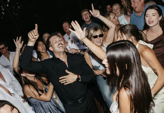 Guests shouting along and dancing in a tight crowd