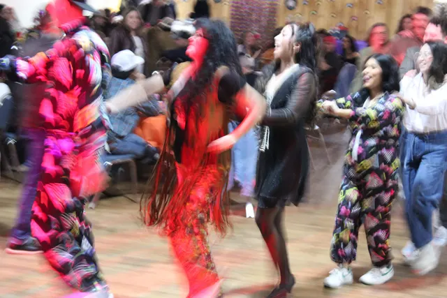 Guests in bright outfits blurring across a packed dance floor