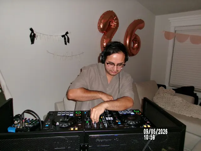 DJ Manny at his booth, the controller and speakers set up around him