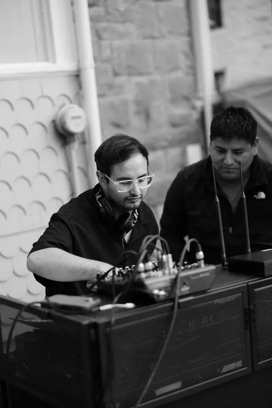 DJ Manny working the decks mid-set, in black and white